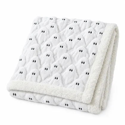 The ghost-print throw folded in half on white, raised ghost texture and embroidered eyes