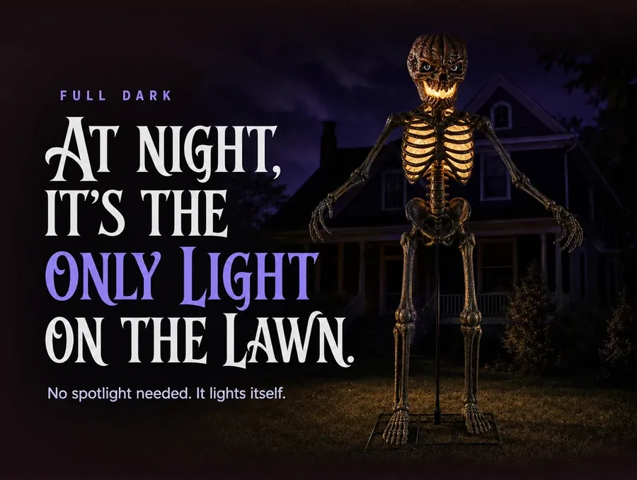 The standing skeleton lit only by its own amber glow in a fully dark yard at night.