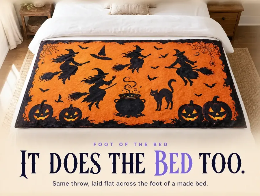 Overhead view of the witch-print throw laid flat across the foot of a made bed in morning light.