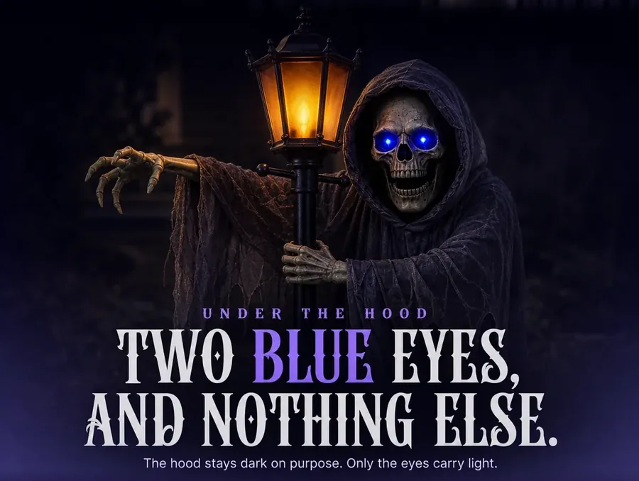 The hooded skull in close-up, its two round blue eyes the only lit thing in the dark