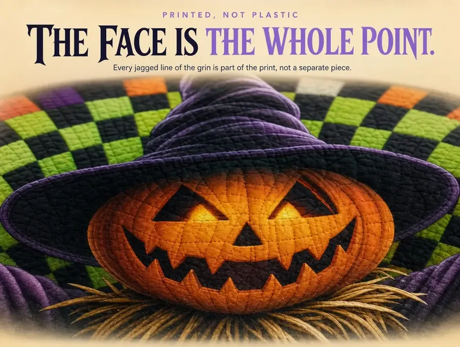 Close-up of a printed pumpkin-headed scarecrow's carved grin and pointed witch hat on a rug