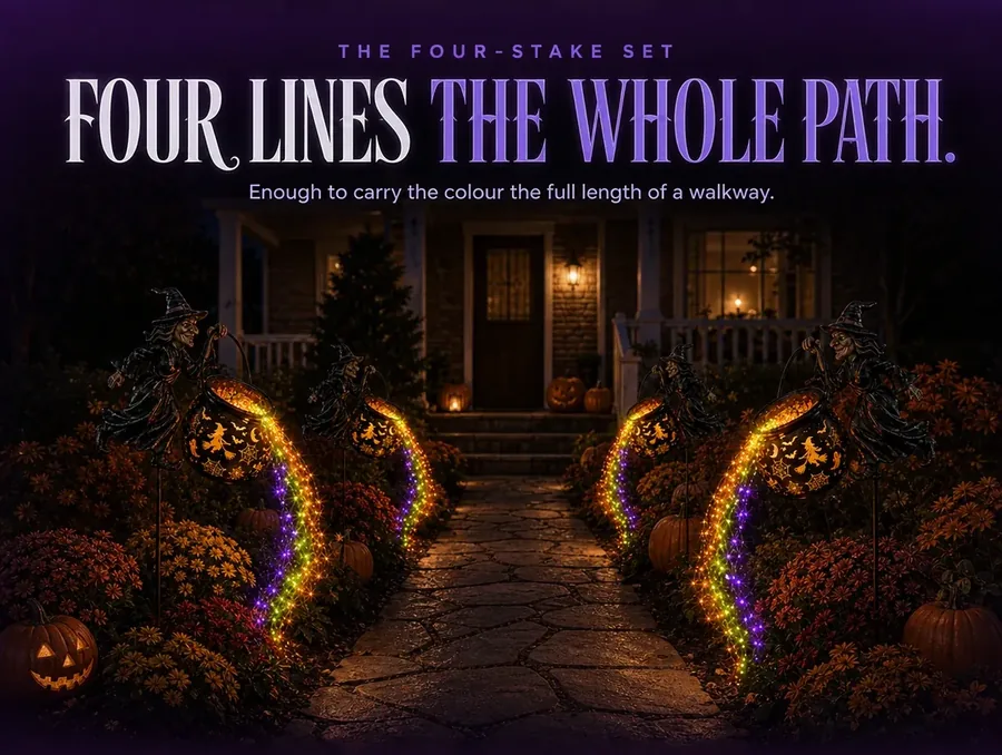 Four matching cauldron stakes lining a full stone walkway at night