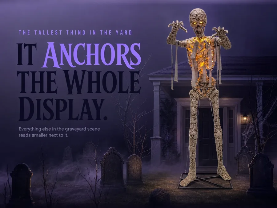 The glowing mummy standing over a small staged graveyard display with headstones and fog at night.